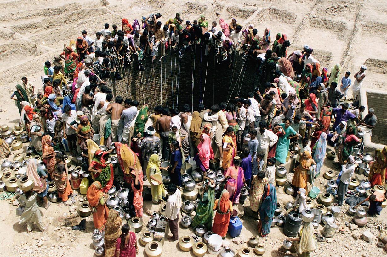 People gather to get water from a huge well in the village of Natwarghad in the western Indian state of Gujarat